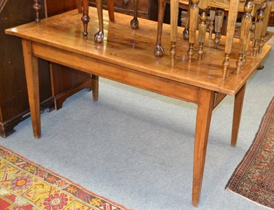 Lot 1387 - A French cherrywood farmhouse table, the rectangular cleated top over a drawer to one end, on...