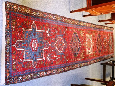 Lot 1436 - Karajah runner, Persian Kurdistan, the ruby field with a row of medallions enclosed by narrow...