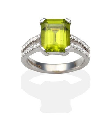 Lot 306 - An 18 Carat White Gold Peridot and Diamond Ring, an octagonal cut peridot in a claw setting, to...