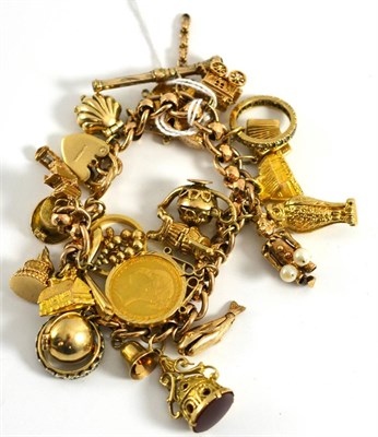 Lot 5026 - A gold charm bracelet with numerous charms, a full sovereign and a half sovereign