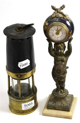 Lot 5065 - A miner's lamp and a French novelty timepiece modelled as a cherub holding aloft a ball