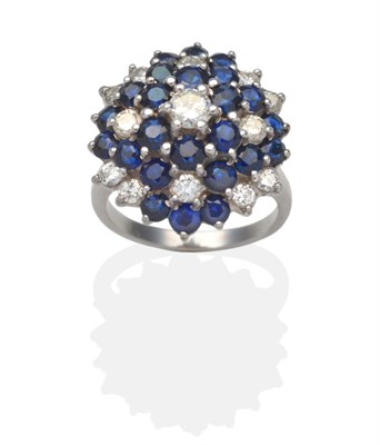 Lot 314 - A Sapphire and Diamond Cluster Ring, a central round brilliant cut diamond within a graduated three