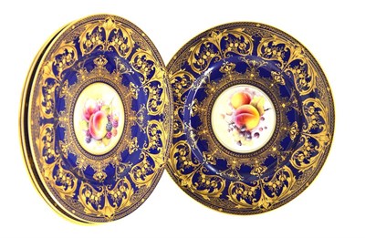 Lot 5104 - Four Royal Worcester plates painted with a vignette of fruit within a cobalt and gilt...