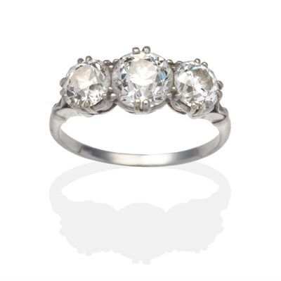 Lot 317 - A Diamond Three Stone Ring, graduated old cut diamonds in white claw settings, to forked...