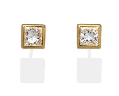 Lot 338 - A Pair of Princess Cut Diamond Solitaire Earrings, in yellow rubbed over settings, total...