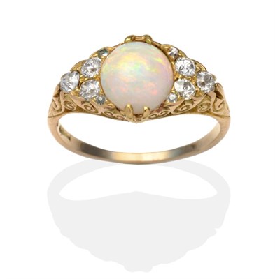 Lot 401 - An Opal and Diamond Ring, an oval opal between old cut diamond accents in a carved yellow...