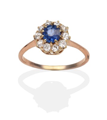 Lot 405 - A Sapphire and Diamond Cluster Ring, a round cut sapphire within a border of old cut diamonds...