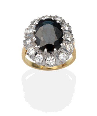 Lot 407 - A Sapphire and Diamond Cluster Ring, an oval cut sapphire within a border of round brilliant...