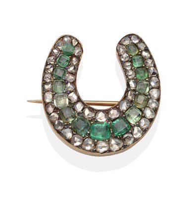 Lot 417 - An Emerald and Diamond Horseshoe Brooch, a central row of octagonal cut emeralds between rows...