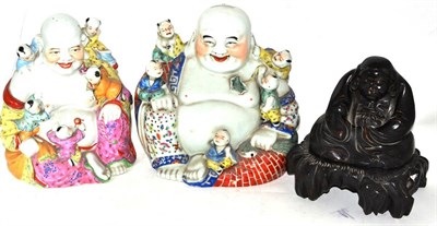 Lot 9 - Two Chinese porcelain figures of Hotei and a carved wood figure of a seated immortal