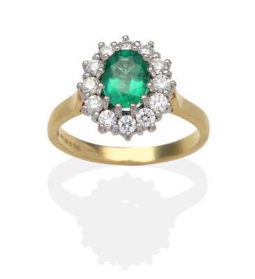 Lot 426 - An 18 Carat Gold Emerald and Diamond Cluster Ring, an oval cut emerald within a border of round...