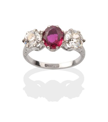 Lot 434 - A Ruby and Diamond Three Stone Ring, an oval cut ruby between old cut diamonds in white claw...