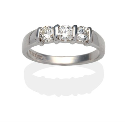 Lot 436 - An 18 Carat White Gold Diamond Three Stone Ring, round brilliant cut diamonds in bar settings...