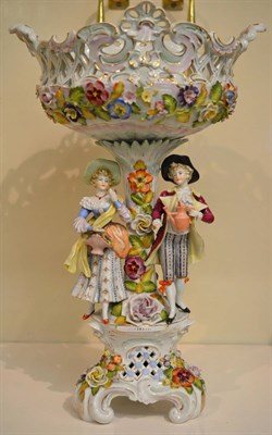 Lot 132 - A Sitzendorf figural centrepiece on a Rococo base with two figures either side of the column...