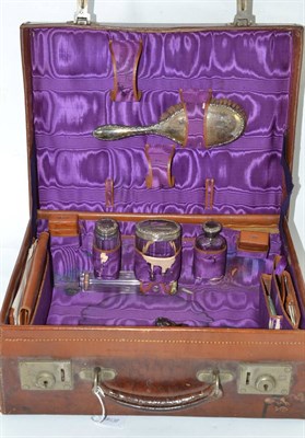 Lot 253 - Leather travelling case with silver topped jars