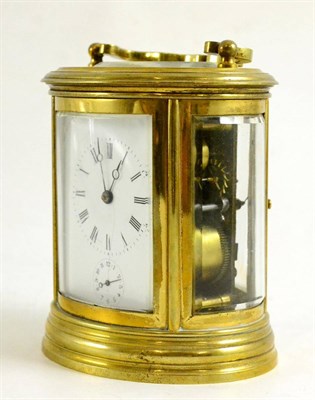 Lot 316 - Oval brass carriage clock with white enamel dial