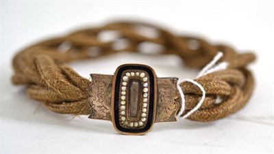 Lot 374 - A woven hair bracelet with a seed pearl mounted locket dated 1832