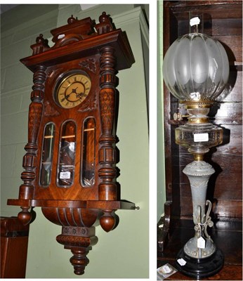 Lot 465 - A wall clock, with a key and pendulum (a loose wooden acanthus leaf) and an oil lamp with glass...