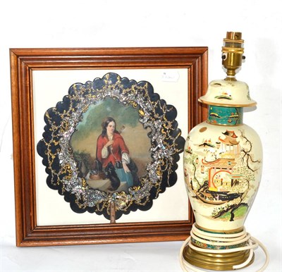 Lot 68 - A chinoiserie decorated table lamp and a papier mache face screen in a glazed frame (2)