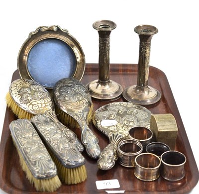 Lot 93 - A pair of silver loaded candlesticks, silver backed dressing table set, seven napkin rings and...