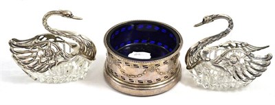 Lot 151 - Silver bottle coaster with blue glass liner and pair of glass swans with silver mounts (3)