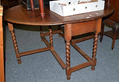 Lot 690 - An Oak drop leaf table with barley twist legs