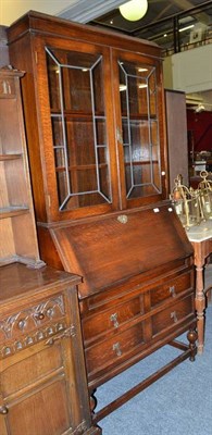 Lot 697 - A 1920's glazed oak bureau bookcase