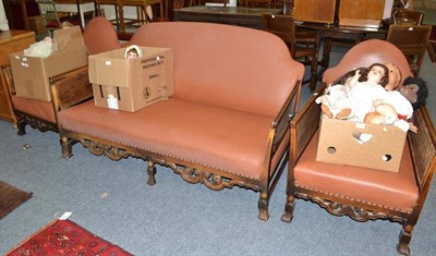 Lot 704 - A bergere cane settee and a pair of armchairs, with brown leather upholstery