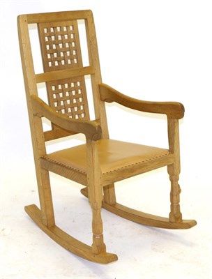 Lot 615 - A Robert  "Mouseman " Thompson Oak Rocking Chair, with two lattice back panels, shaped arms and tan