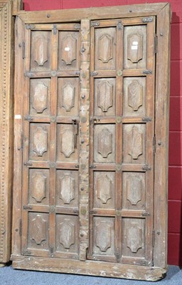 Lot 901 - A pair of 18th century teak ten fielded panel doors, with shield like forms held in its...