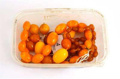 Lot 4 - A part strand of amber beads, two loose amber beads, two simulated amber necklaces and pair of...