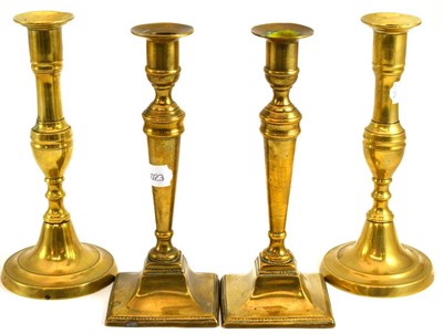 Lot 66 - Two pairs of Georgian brass candlesticks