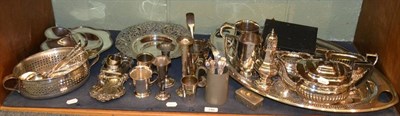 Lot 140 - A shelf of plated ware including an oval tray, pierced bowl, a tea set, mugs, sugar caster, etc