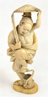 Lot 334 - A good Japanese Meji period carved ivory okimono of a man, his foot being bitten by a snake,...