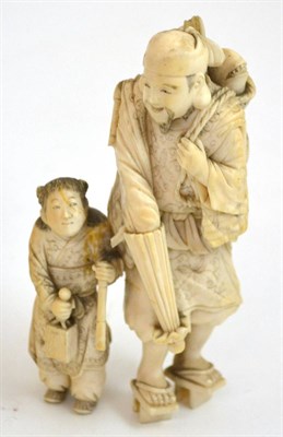 Lot 341 - A good Japanese Meji period carved ivory okimono of a young child and a man, each wearing robes...