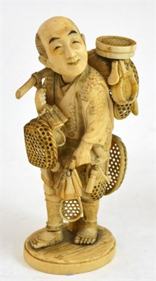 Lot 342 - A good Japanese Meji period carved ivory okimono of a basket maker, the slouched man with many...