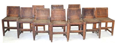 Lot 679 - A Set of Ten Yorkshire Oak Panel Back Chairs, solid seats, joined by rails, unmarked, 72cm