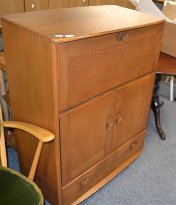 Lot 1136 - An Ercol elm drinks cabinet bureau, labelled, 82.5cm by 49cm by 110cm high; an Ercol elm tea...