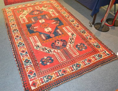 Lot 1231 - A Kasim Ushak rug, South Caucasus, the tomato red ground centred by a cruciform panel framed by...