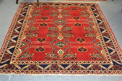 Lot 1233 - Afghan rug, the blood red field with stylised plants enclosed by indigo borders, 203cm by 163cm