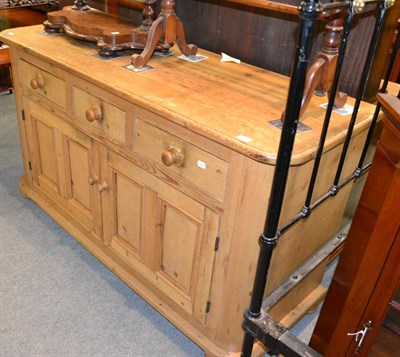 Lot 1361 - A pine sideboard with three drawers over two panelled cupboard doors