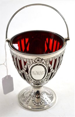 Lot 34 - A Victorian silver sugar basket with ruby glass liner, London 1882