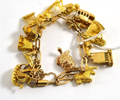 Lot 52 - A charm bracelet hung with charms including the London Bridge, tram, church, boats (mainly 9ct...