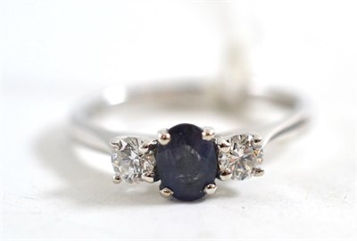 Lot 69 - An 18ct white gold alexandrite and diamond three stone ring, the oval cut alexandrite flanked...