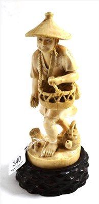 Lot 340 - A Japanese ivory figure of a farmer, with wood stand, circa 1900