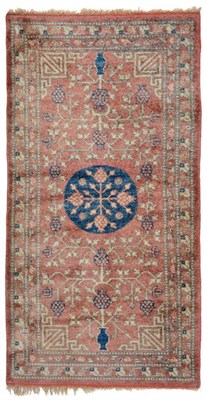 Lot 778 - Khotan Silk Rug East Turkestan, circa 1925 The soft terracotta field centred by an indigo...