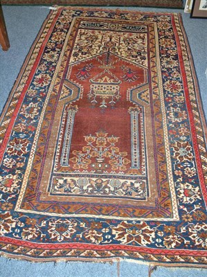 Lot 655 - An Anatolian prayer rug, the rust field with hanging lamp beneath the Mihrab framed by ivory...