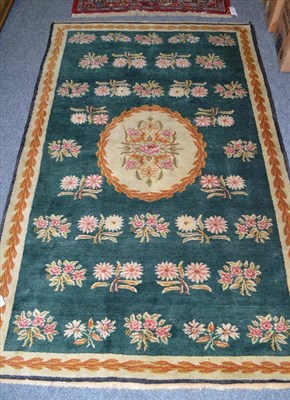 Lot 656 - Savonnerie design rug, probably Karabagh, the apple green field with floral sprays centred by a...