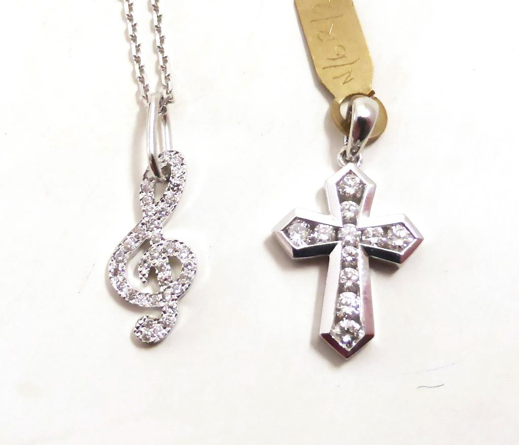 Lot 95 - A diamond set cross charm, stamped '750' and an 18ct white gold diamond set treble clef charm...