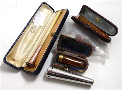 Lot 223 - An Edwardian gold mounted ivory cheroot holder and three gold mounted amber cheroot holders (one in